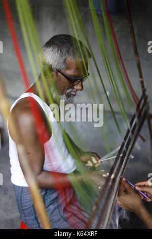 Artisan weaving Jamdani saree on the traditional handloom at Rupganj. Jamdani is a superfine handloom fabric, which has evolved through generations of Stock Photo