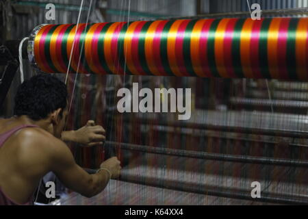 Artisan weaving Jamdani saree on the traditional handloom at Rupganj. Jamdani is a superfine handloom fabric, which has evolved through generations of Stock Photo