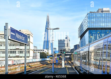 Waterloo East train station sign on platform with public transport electric passenger train & Shard skyscraper landmark building beyond England UK Stock Photo