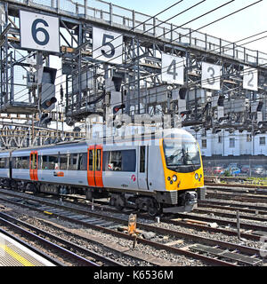 Heathrow Connect train & carriages just after depart Paddington for London Heathrow Airport UK below signal gantry with large numbers safety feature Stock Photo