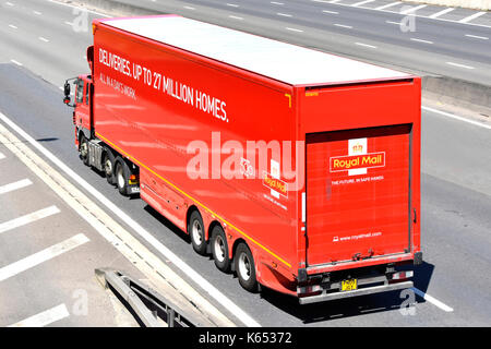 Deliveries up to 27 million homes advert on side of red Royal Mail articulated trailer with hgv lorry truck unit driving along UK motorway Stock Photo