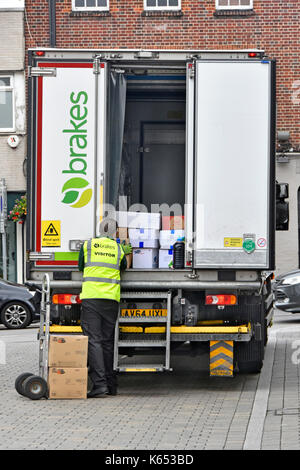 Close up of parked Brakes wholesale food supply chain lorry truck delivery driver everyday unloading boxes onto trolley in Brentwood Essex England UK Stock Photo