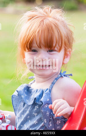 A MODEL RELEASED 2 year old girl with ginger hair outdoors in the Uk Stock Photo