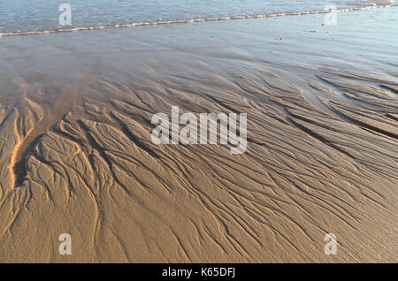 Beach sand texture formed by water. Nature backgrounds Stock Photo