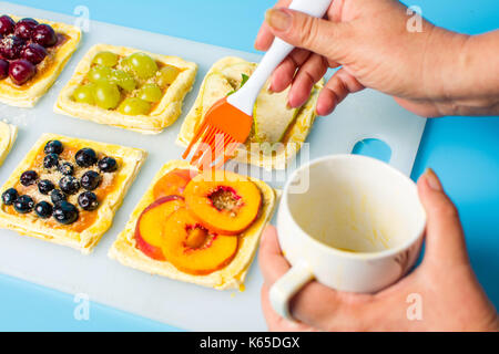 Chef applying egg on the fruit sweet pie before baking Stock Photo