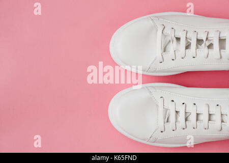 Overhead Shot Of White Sneakers On Pink Background Stock Photo