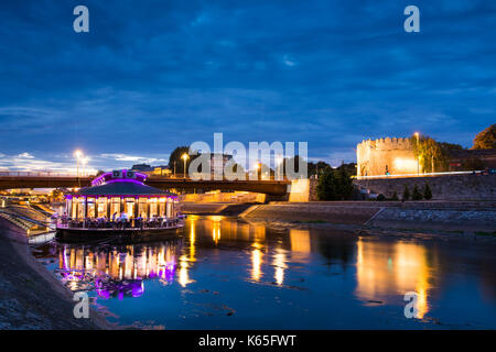 NIS, SERBIA - September 8, 2017: Nis fortress entrance reflected in Nisava river with floating coffee bar with University building in the background.  Stock Photo