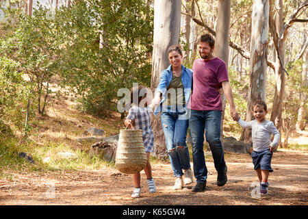 Family Walking Along Path Through Forest Together Stock Photo