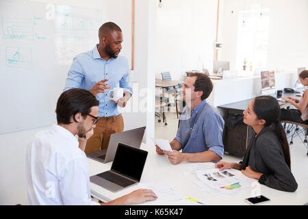 Young black man presenting an office meeting at a whiteboard Stock Photo