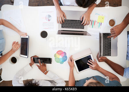Business people using computers at a desk, overhead shot Stock Photo