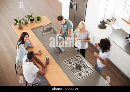 Overhead View Of Friends Drinking Coffee In Modern Kitchen Stock Photo