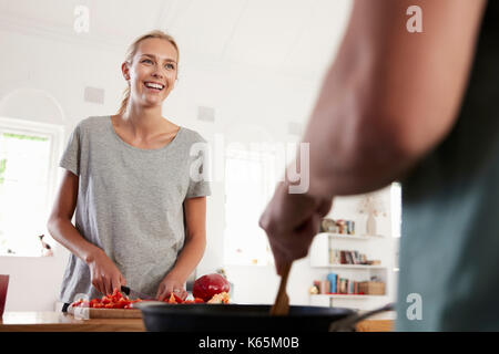 Couple Preparing Meal Together In Modern Kitchen Stock Photo