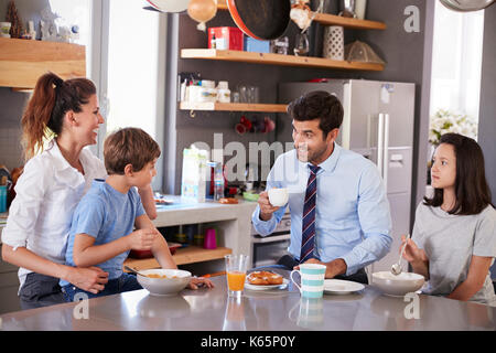 Father Having Family Breakfast In Kitchen Before Leaving For Work Stock Photo