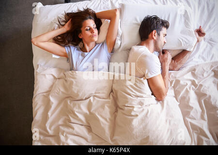 Overhead View Of Couple With Relationship Problems Lying In Bed Stock Photo