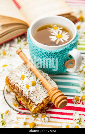 Honeycomb and chamomile tea on white Stock Photo