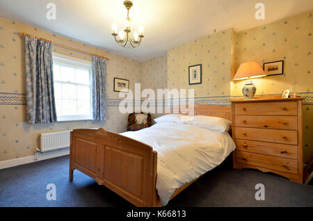 Guest bedroom in country cottage with pine furniture Stock Photo