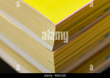 thickness of old versions of yellow pages classified telephone directory paper edition uk Stock Photo