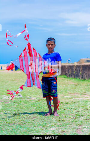 Little boy with colorful kite on the field at Galle Dutch fort Stock Photo