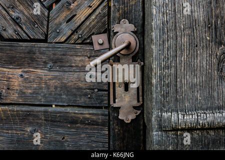 Old wooden door with iron handle on the church. Old Door Handle. Stock Photo