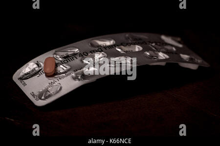 A statin tablet on an empty packet. Stock Photo