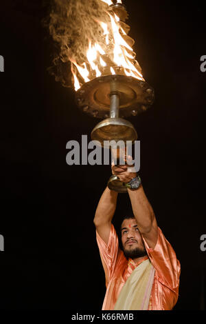 VARANASI, INDIA - CIRCA NOVEMBER 2016:  Young pandit performing the Ganga Aarti ceremony at the  Dasaswamedh Ghat in Varanasi. The Aarti is a powerful Stock Photo