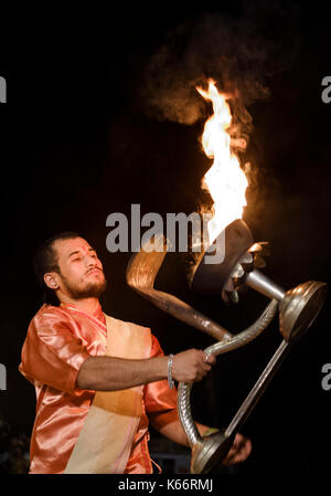 VARANASI, INDIA - CIRCA NOVEMBER 2016:  Young priest performing the Ganga Aarti ceremony at the  Dasaswamedh Ghat in Varanasi. The Aarti is a powerful Stock Photo