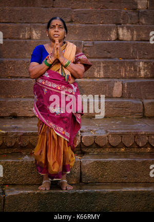 VARANASI, INDIA - CIRCA NOVEMBER 2016: Hindu woman worshiping in Varanasi. Varanasi is the spiritual capital of India, the holiest of the seven sacred Stock Photo