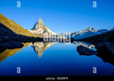 The East Face of the Matterhorn, Monte Cervino, mirroring in the Lake Riffelsee at sunrise Stock Photo
