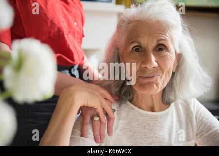 Hand of daughter on shoulder of older mother Stock Photo