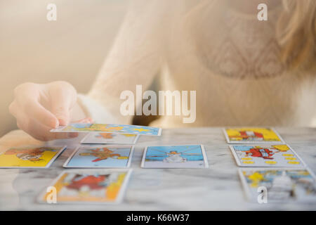 Caucasian woman using tarot cards Stock Photo