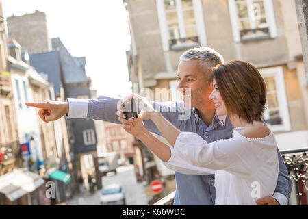 Caucasian couple photographing with cell phone in city Stock Photo
