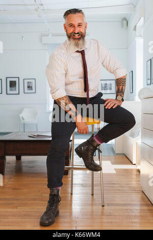 Portrait of smiling Caucasian businessman with tattoos Stock Photo