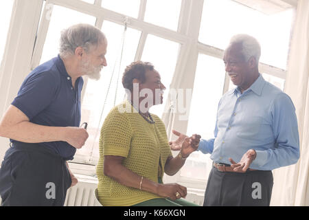 Older people laughing near window Stock Photo