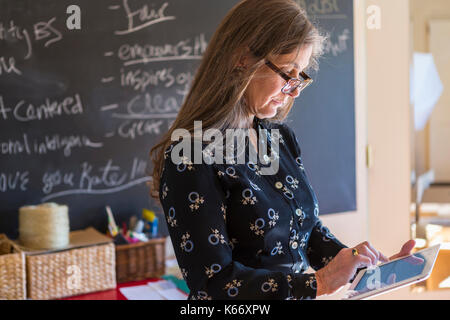 Caucasian teacher using digital tablet in classroom Stock Photo