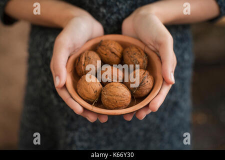 Hands holding bowl of walnuts Stock Photo