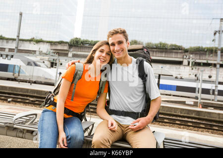 Caucasian couple waiting on bench at train station Stock Photo