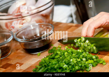 Hands of woman chopping onions on cutting board Stock Photo