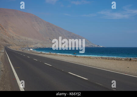 Road (Route 1) running along the Pacific coast in the Antofagasta Region of northern Chile where the Atacama Desert meets the ocean. Stock Photo