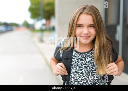 Elementary school pupil outside carrying rucksack Stock Photo