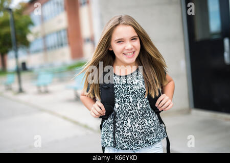 Elementary school pupil outside carrying rucksack Stock Photo