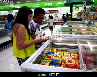 ANTIPOLO CITY, PHILIPPINES - SEPTEMBER 10, 2017: Customers choose from a variety of processed meat products at a grocery store. Stock Photo