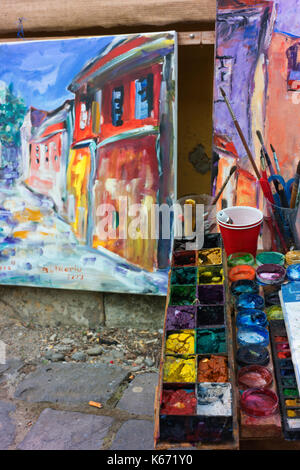 An artists paints and brushes, along with completed works, in Sighisoara's Old Town. Stock Photo