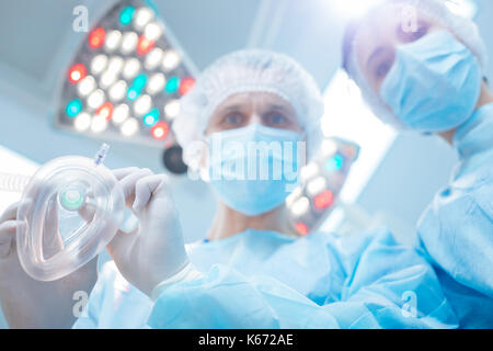 Two doctors standing over patient Stock Photo