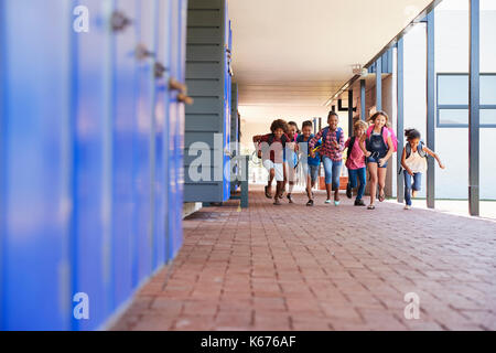 School kids running to camera in elementary school hallway Stock Photo