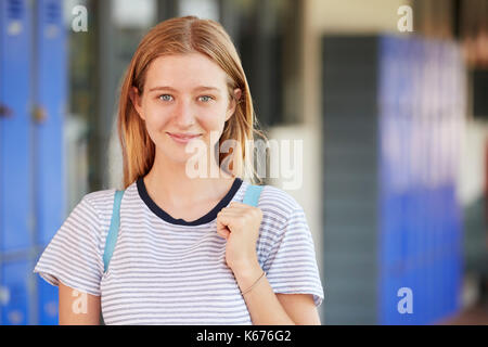Happy white teenage girl smiling in high school corridor Stock Photo
