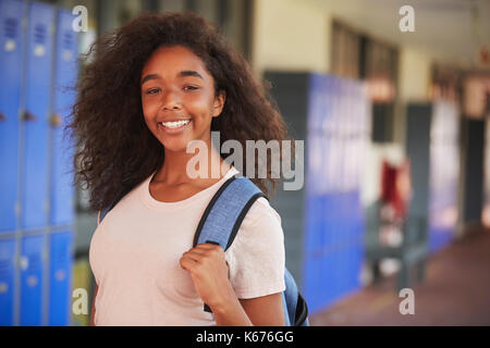 Happy black teenage girl smiling in high school corridor Stock Photo