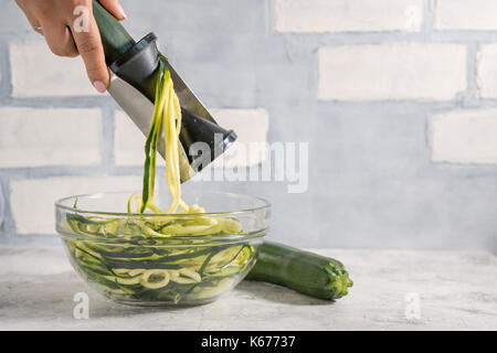 Making zucchini noodles with spiralizer. Diet low carb food Stock Photo