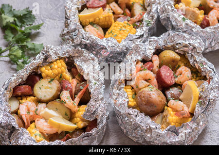 Homemade Traditional Cajun Shrimp Boil with Sausage Potato and Corn foil pack Stock Photo
