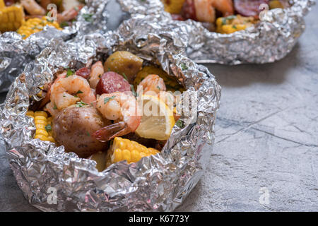 Homemade Traditional Cajun Shrimp Boil with Sausage Potato and Corn foil pack Stock Photo