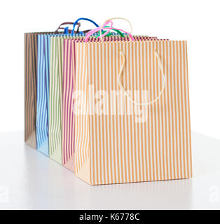 colorful striped shopping bags arranged in a row, object isolated on white Stock Photo